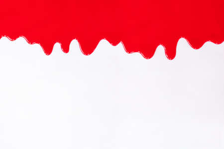 Red paint dripping on a white backgroundの写真素材