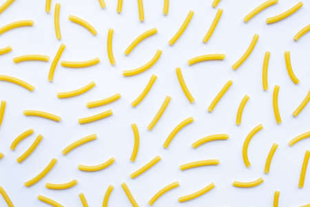 Uncooked macaroni on a white white background.の写真素材