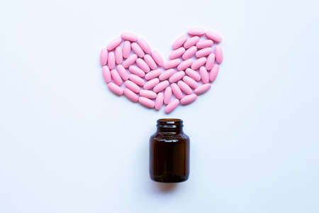 Pink medicine pills on white background. Heart shapeの写真素材
