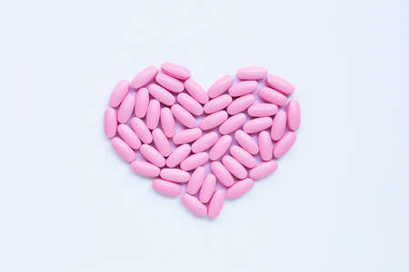 Pink medicine pills on white background. Heart shapeの写真素材