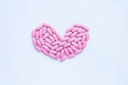Pink medicine pills on white background. Heart shapeの写真素材