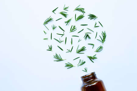 Medical bottle glass with fresh rosemary leaves isolated on white background. Heart shapeの写真素材