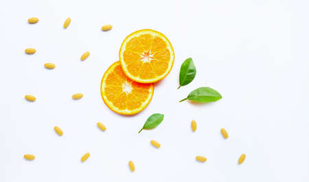 Vitamin C pills with orange fruit on white backgroundの写真素材