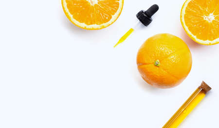 Essential oil with oranges on white background.