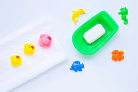 Pink and yellow duck  toys on white towel with  soap  and sea animals on white background. Kids bath...