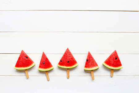Watermelon slice on stick on white wooden background. Copy spaceの写真素材