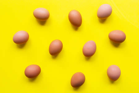 Eggs on yellow background. Top viewの写真素材