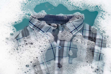 Shirt soak in powder detergent water dissolution, washing cloth. Laundry concept