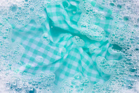 Green white tablecloth  soak in powder detergent water dissolution, washing cloth. Laundry conceptの写真素材