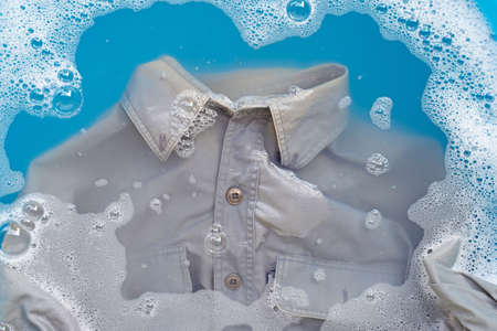 Shirt soak in powder detergent water dissolution, washing cloth. Laundry conceptの写真素材