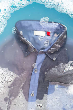 Shirt soak in powder detergent water dissolution, washing cloth. Laundry conceptの写真素材