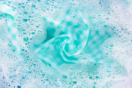 Green white tablecloth  soak in powder detergent water dissolution, washing cloth. Laundry conceptの写真素材