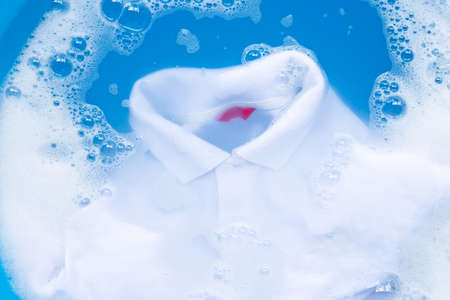 White polo shirt soak in powder detergent water dissolution, washing  cloth. Laundry concept