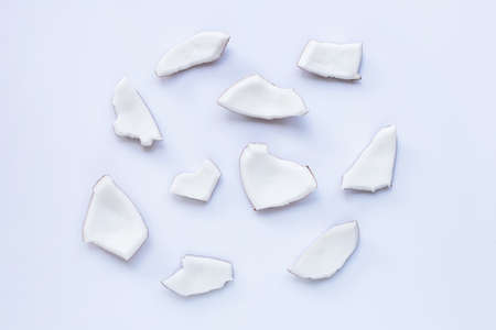 Coconut pieces on white background. Top view of tropical fruit.