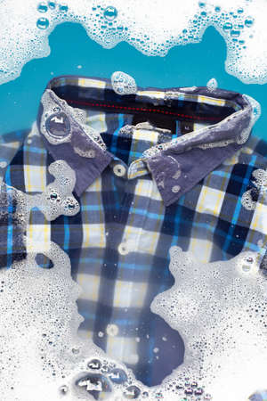 Shirt soak in powder detergent water dissolution, washing  cloth. Laundry concept