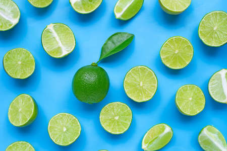 Limes with leaf on blue background. Top viewの写真素材