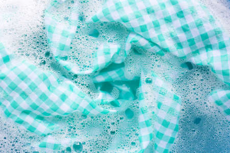 Green white tablecloth  soak in powder detergent water dissolution, washing cloth. Laundry concept