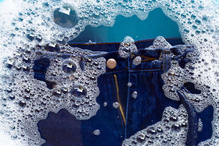 Jeans soak in powder detergent water dissolution, washing  cloth. Laundry concept