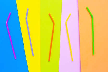 Colorful plastic  straws on colorful background. Plastic waste pollution.