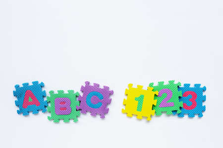 Alphabet puzzle with number puzzle on white background. Copy spaceの写真素材