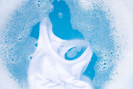 White kid undershirt soak in baby laundry detergent water dissolution, washing cloth, blue...