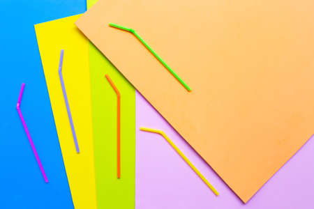 Colorful plastic  straws on colorful background. Plastic waste pollution.