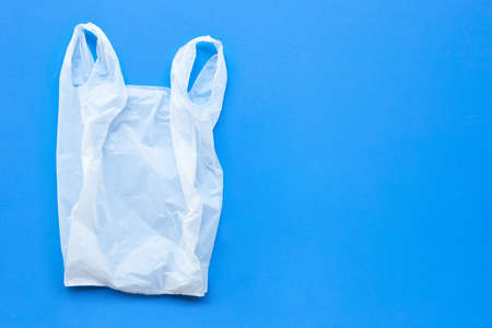 White plastic bag on blue background. Copy space