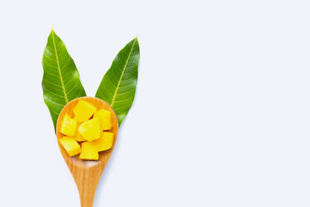 Tropical fruit, Mango cube slices with wooden spoon and leaves on white background. Copy spaceの写真素材