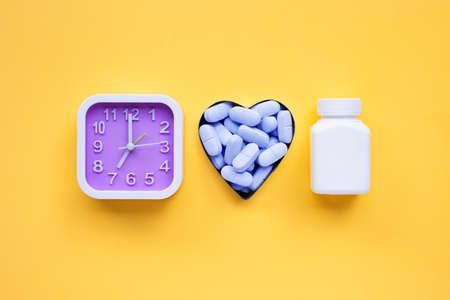 Clock with "PrEP" ( Pre-Exposure Prophylaxis). used to prevent HIV on yellow background. Top viewの写真素材