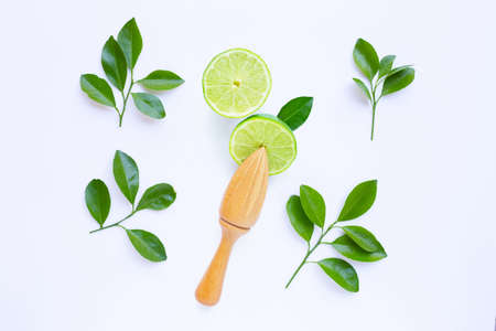 Fresh limes with wooden juicer on white background. Top view の写真素材
