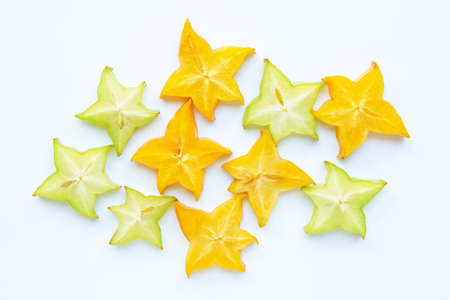 Green and yellow sliced ripe star fruit on white backgroundの写真素材
