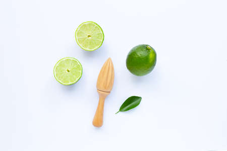 Fresh limes with wooden juicer on white background.  Copy spaceの写真素材