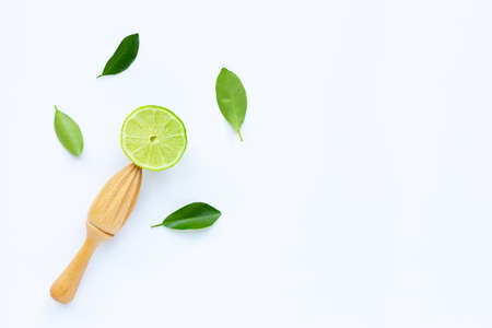 Fresh lime with wooden juicer on white background.  Copy space