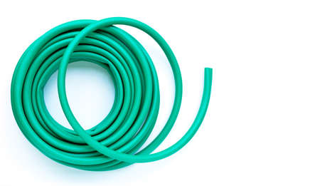 Green garden hose on white background. Copy space