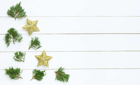Merry Christmas and Happy Holidays, Christmas composition. golden stars, pine branches on white wooden background. Top viewの写真素材