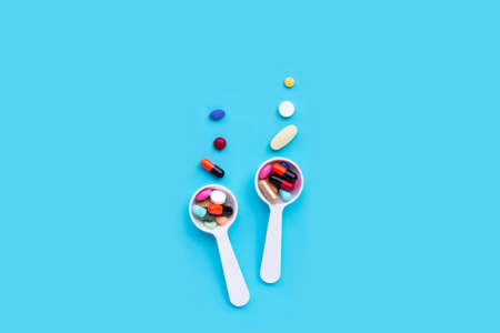 Colorful medicine pills, tablets and capsules on blue background. Copy spaceの写真素材