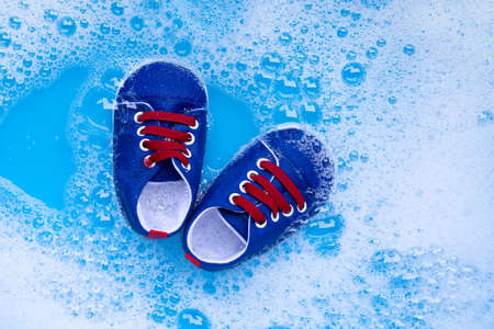 Soak baby shoes in baby laundry detergent water dissolution before washing.  Laundry concept, Top...