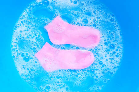 Pink  socks soaking in powder detergent water dissolution. Laundry concept.