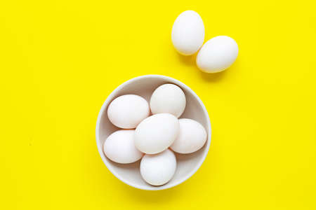 White eggs on yellow background.  Top viewの写真素材
