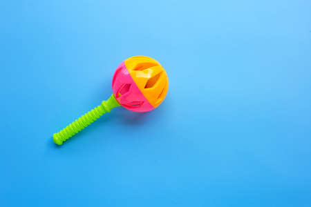Colorful baby rattle on blue background. Copy spaceの写真素材