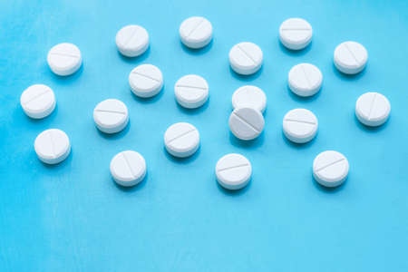Tablets of Paracetamol on blue background.  Copy space