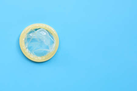 Condom on blue background. Copy space, Top view