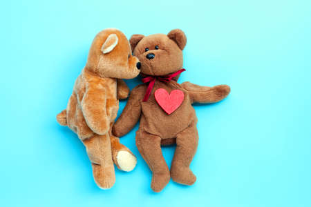 Brown bear toys kissing with red heart on blue background. Valentine's Day, Copy spaceの写真素材