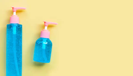 Alcohol hand sanitizer gel in pump bottles for hand hygiene corona virus (Covid-19) protection. Yellow background with copy spaceの写真素材