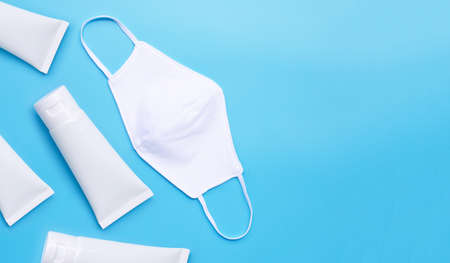 Cloth mask and Alcohol hand sanitizer gel in white glossy plastic tubes for hygiene corona virus...