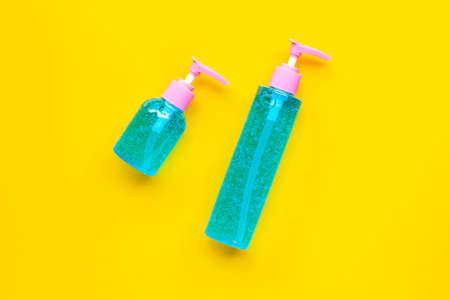 Alcohol hand sanitizer gel in pump bottles on yellow background. Copy spaceの写真素材