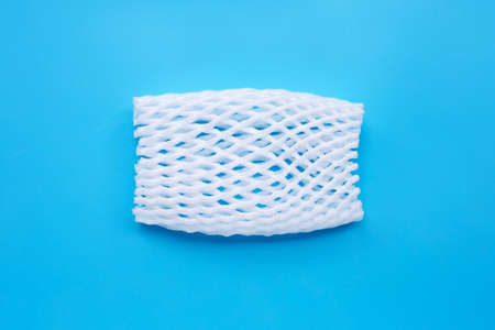 Fruit foam net for protection on blue background. Top view