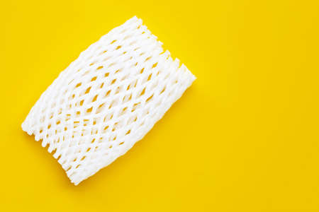 Fruit foam net for protection on yellow background. Top viewの写真素材
