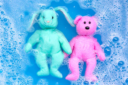Soak rabbit doll with  toy teddy bear in laundry detergent water dissolution before washing. ...