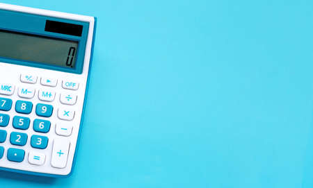 Calculator on blue background, top view with copy space